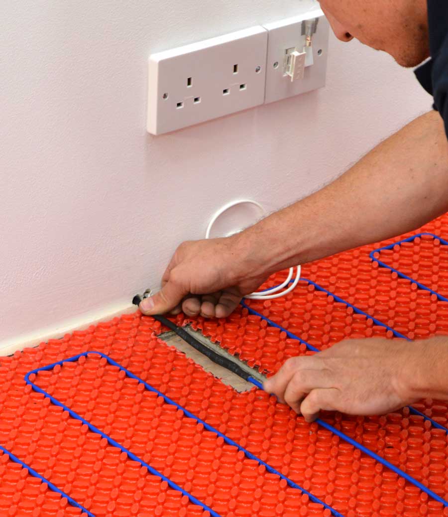 Elektrische Fußbodenheizung wird von einem zertifizierten Elektriker an den Strom angeschlossen